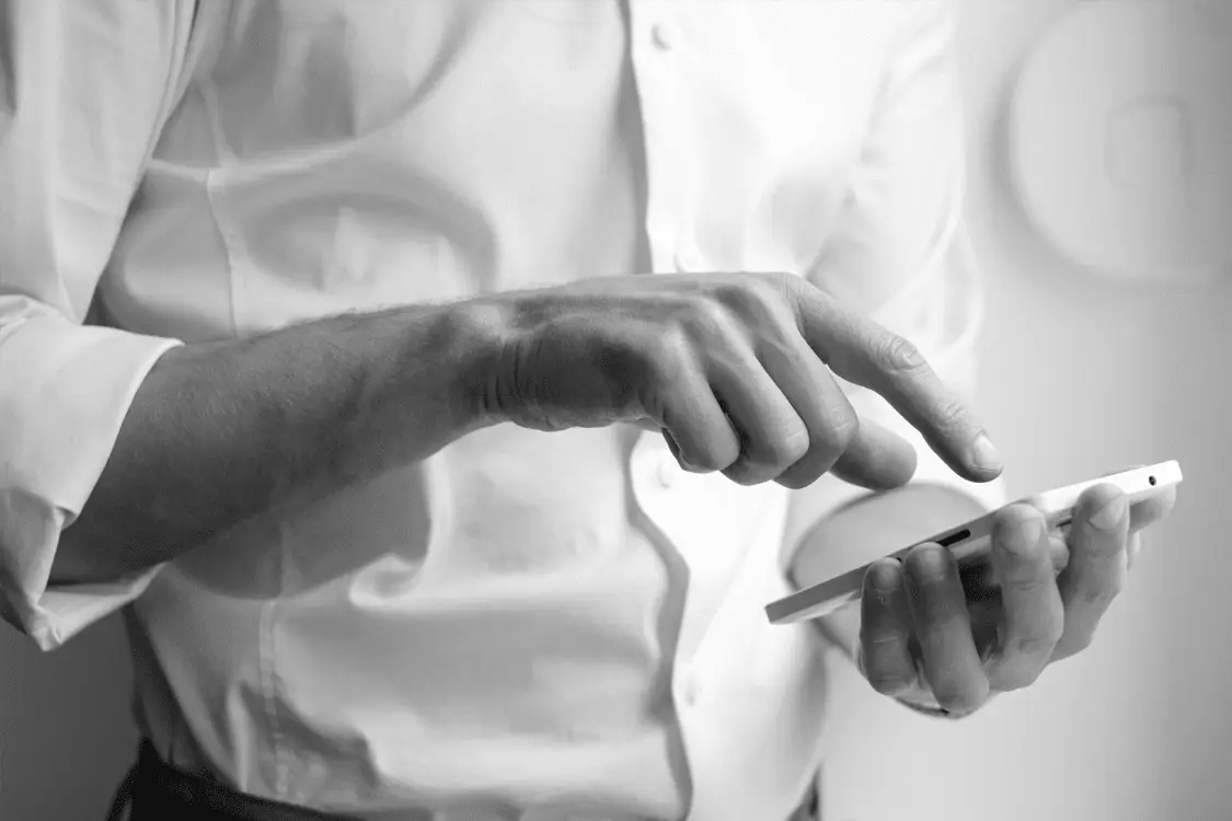 Close-up of a person using a smartphone, representing urgency in responding to phishing threats